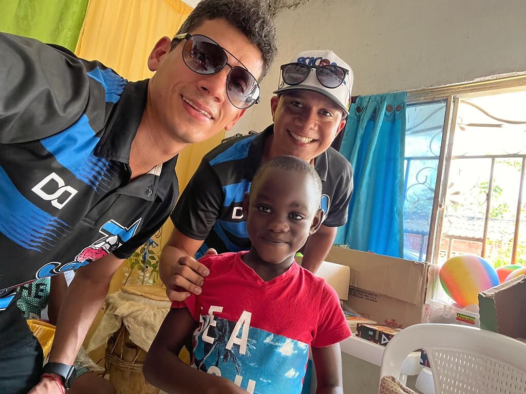 Tres hombres de la fundación, uno cargando un niño pequeño en brazos