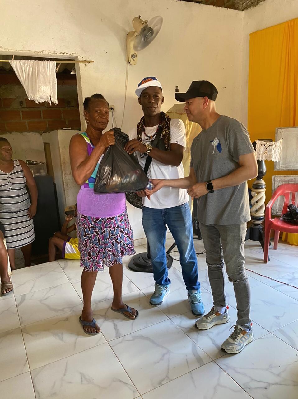 Una mayor de la comunidad recibiendo apoyo de los líderes de la fundación