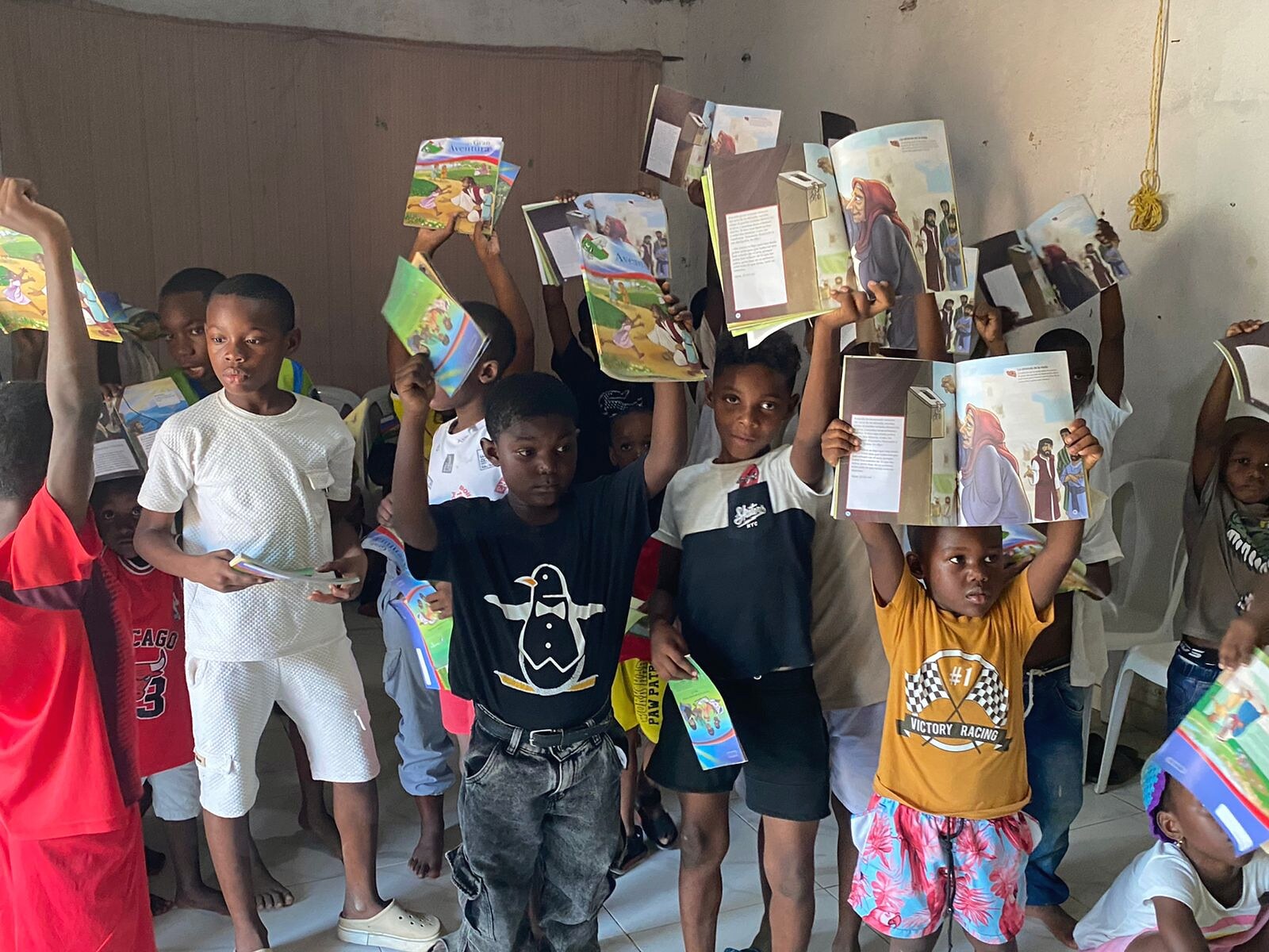 Niños sosteniendo paquetes en alto durante una jornada