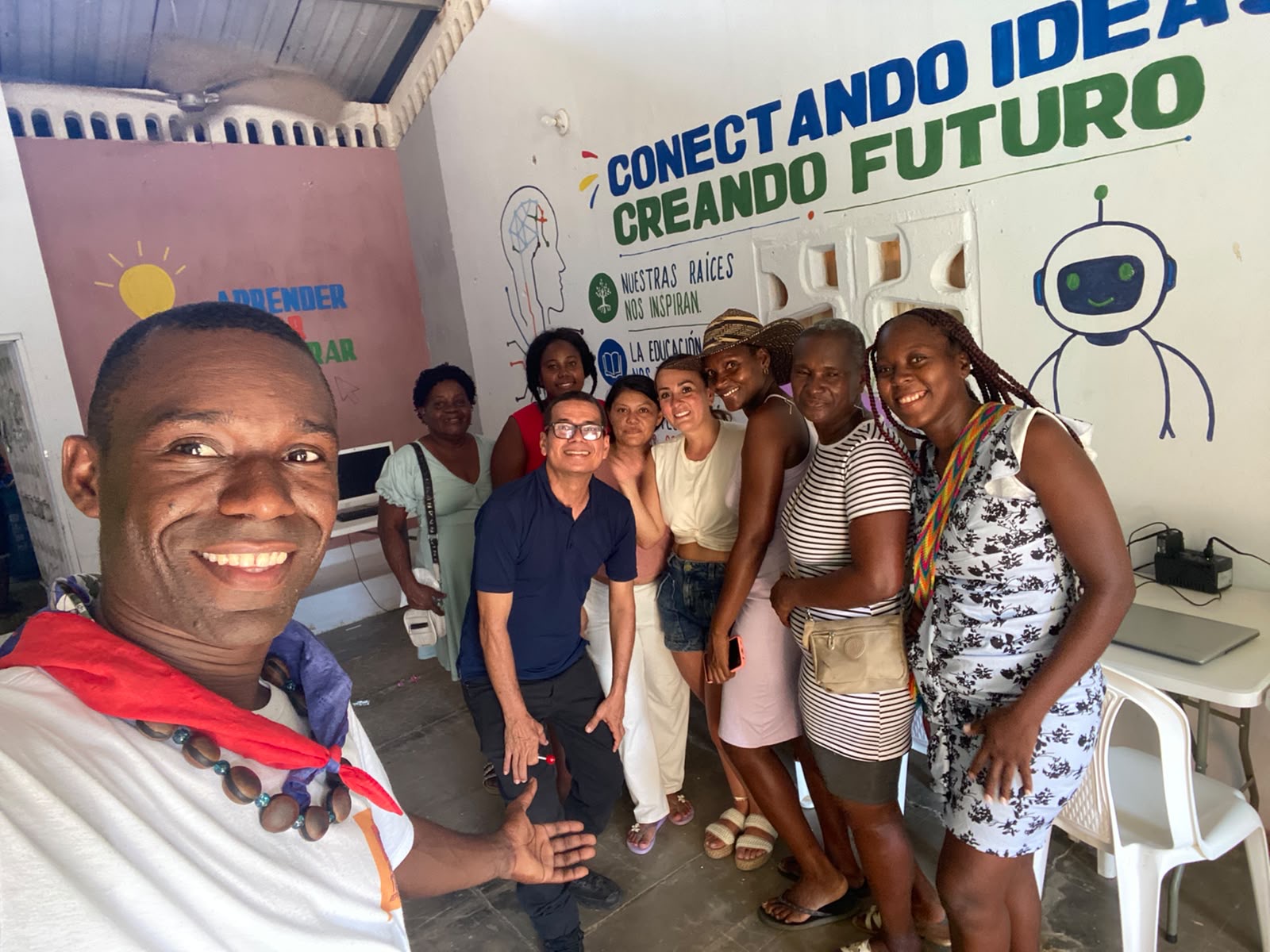 Keiner con miembros de la comunidad frente al mural 'Conectando ideas, Creando futuro'