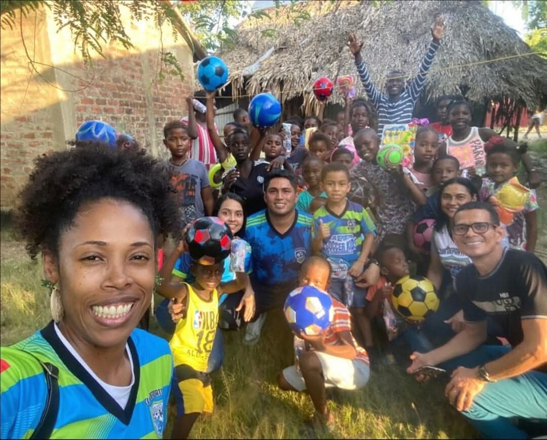 Niños y entrenadores en una jornada del programa de fútbol con balones de colores